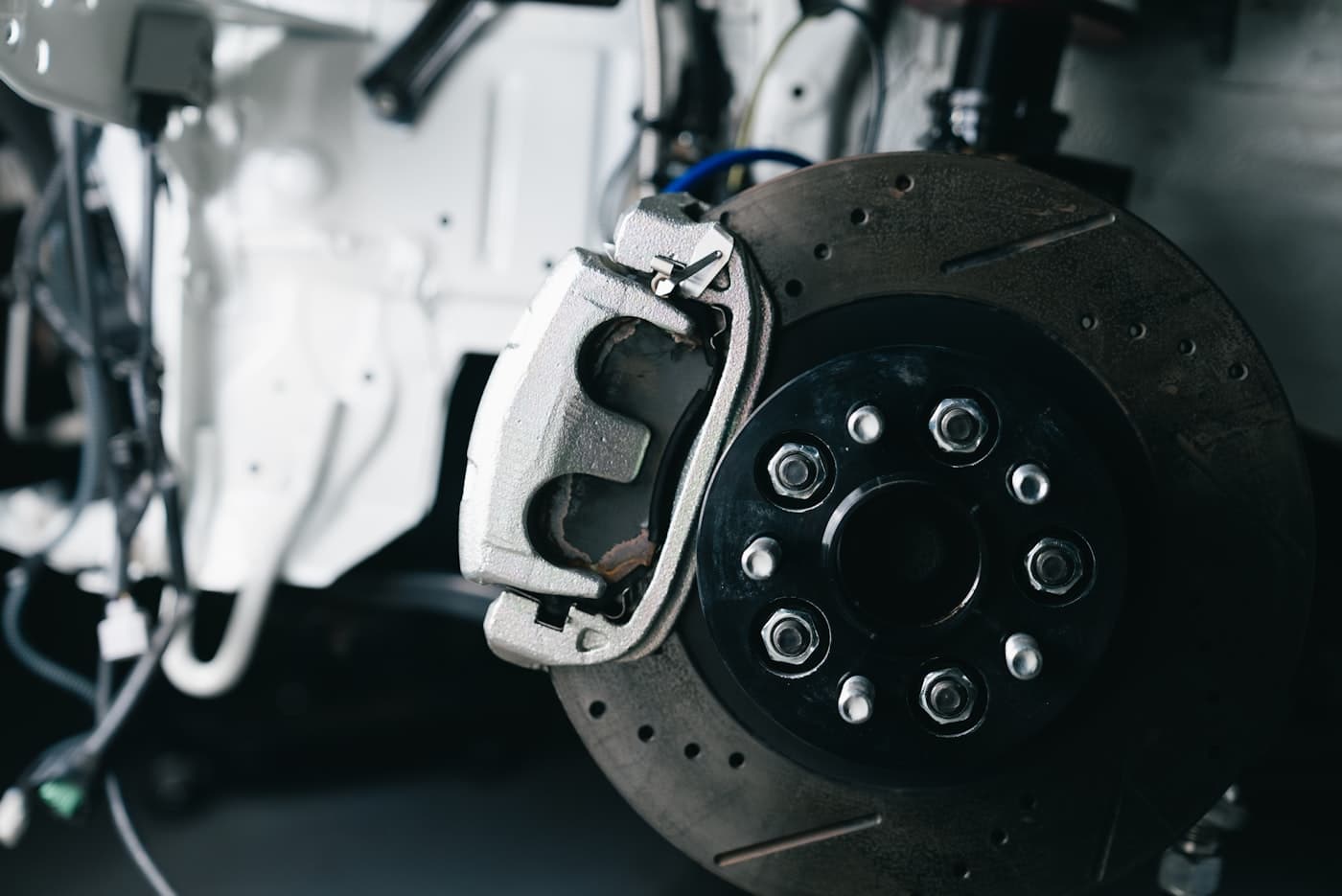 Close up of a brake disc and caliper in a tidy workshop bay