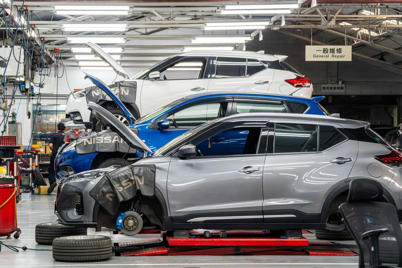 Clean workshop with modern cars on ramps under bright lights